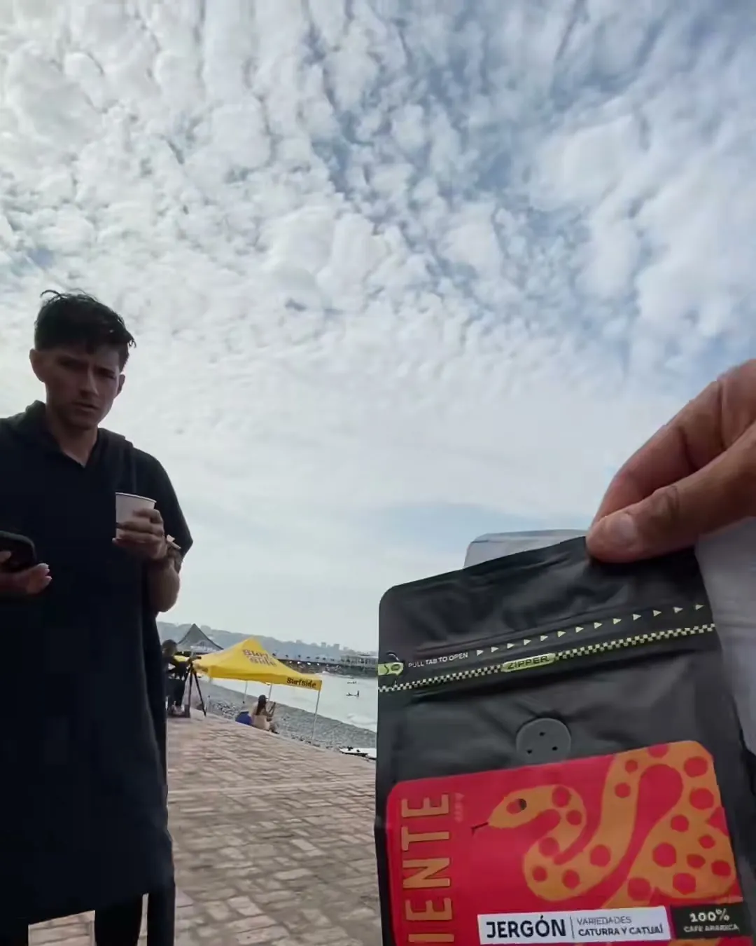 Bolsa de café Caliente Dardo del Monte en la mano, frente al mar